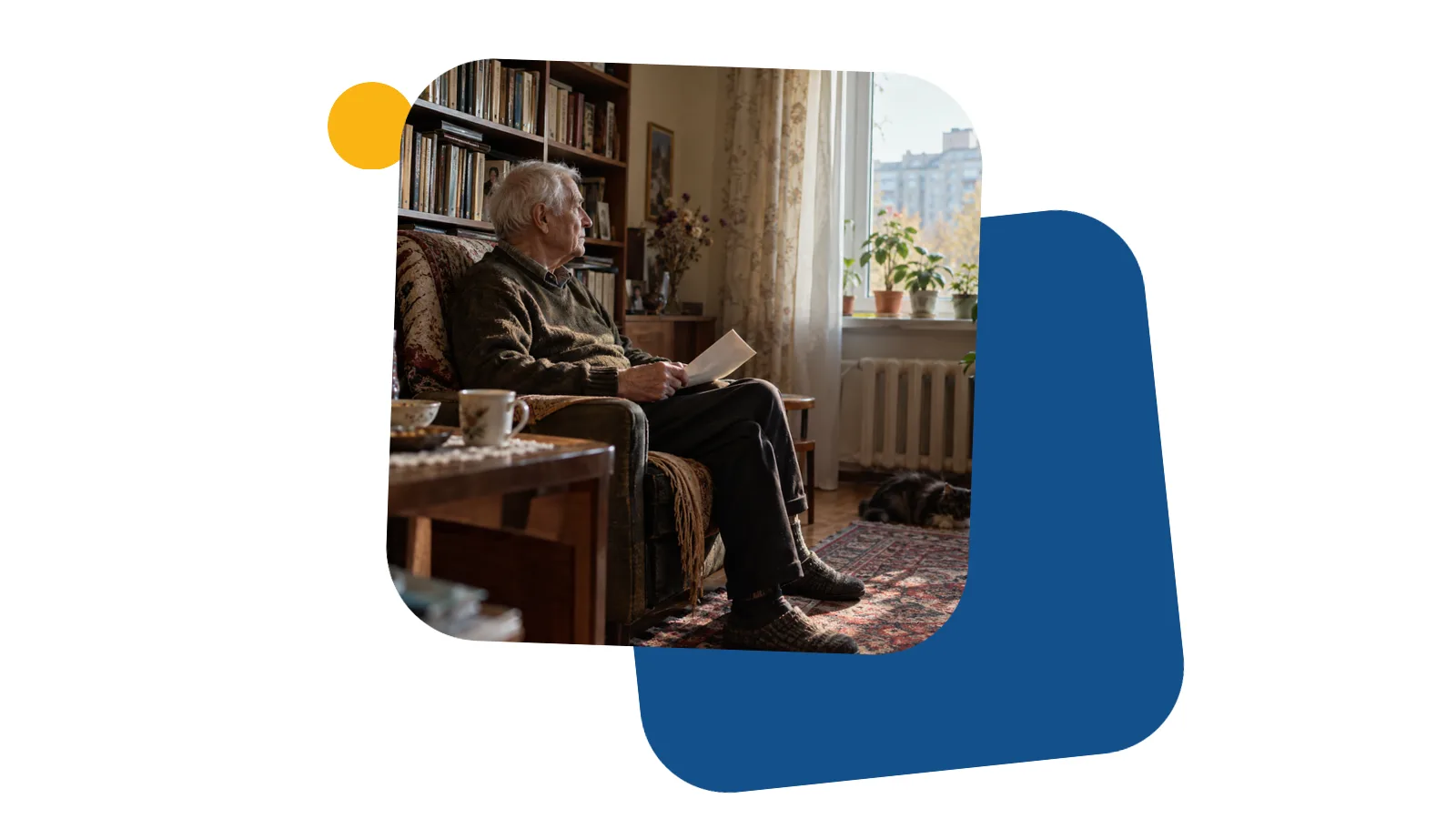 Літній чоловік сидить у кріслі біля книжкової полиці у вітальні й тримає в руках складений аркуш паперу, видно його збоку